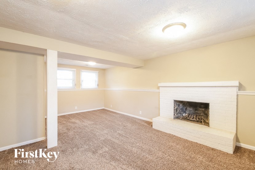 an empty living room with a fireplace and a window