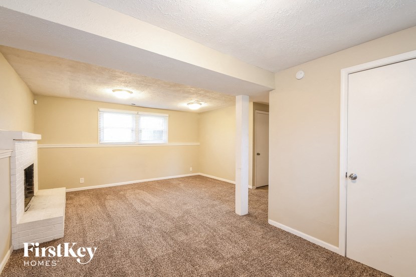 an empty living room with a fireplace and a door to a closet