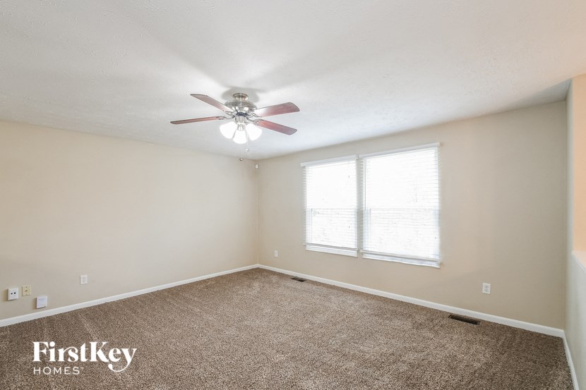 a bedroom with a ceiling fan and a window