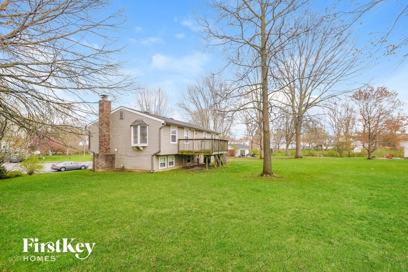 a house in the middle of a field with a tree