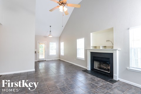 a living room with a fireplace and a ceiling fan