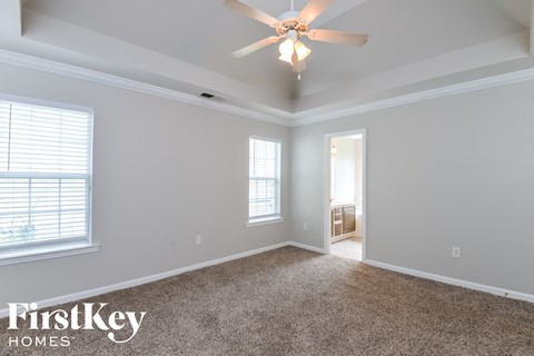 the master bedroom has a ceiling fan and carpeted flooring