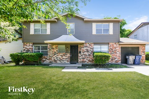 the front of a house with a lawn and a driveway