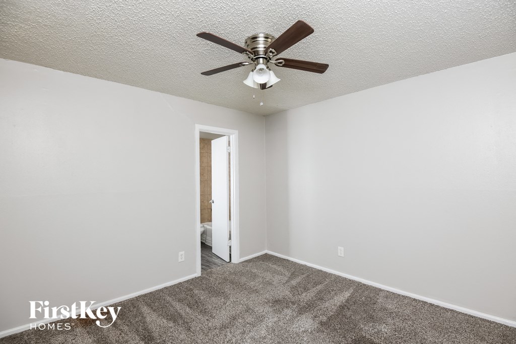 a living room with carpet and a ceiling fan