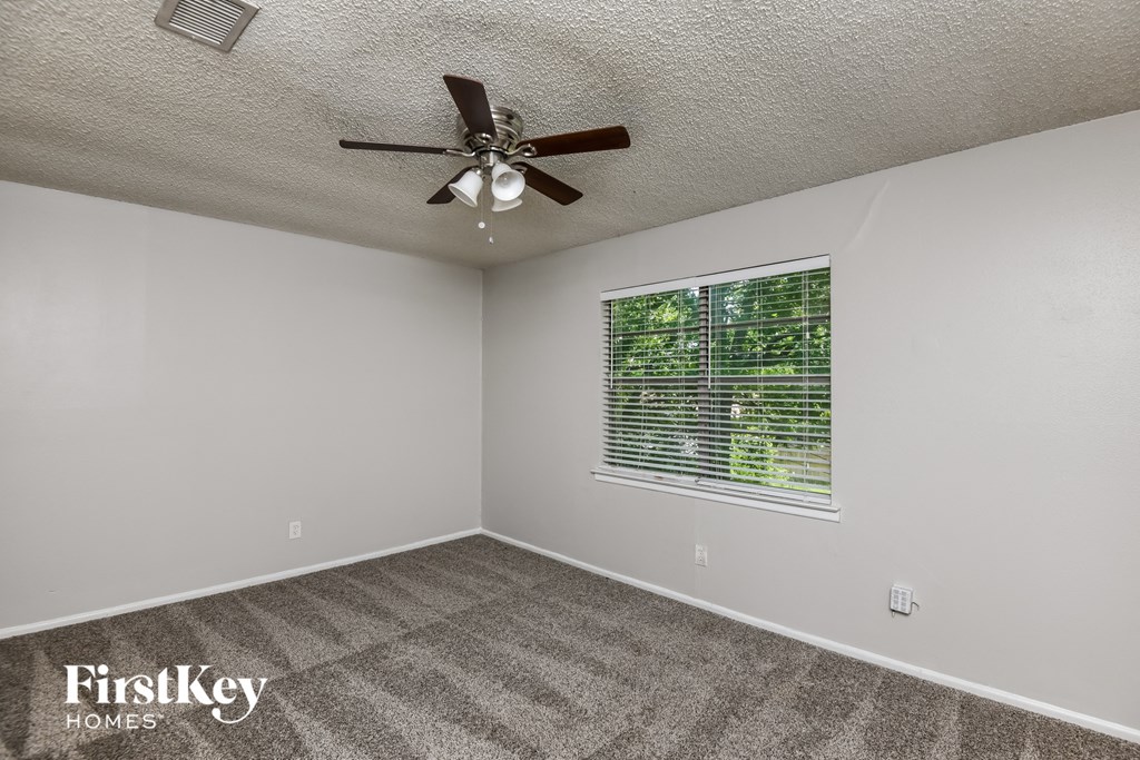 the living room has a ceiling fan and a window
