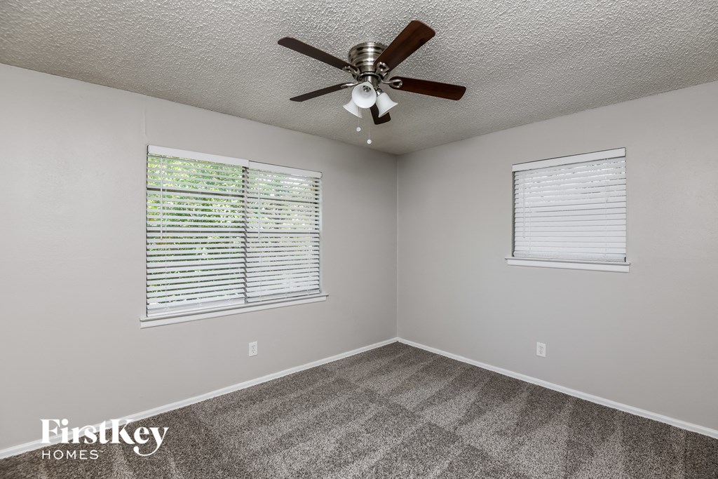 the bedroom has a ceiling fan and a window