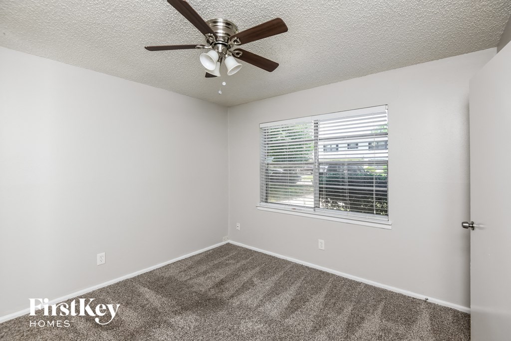 the living room has a ceiling fan and a window