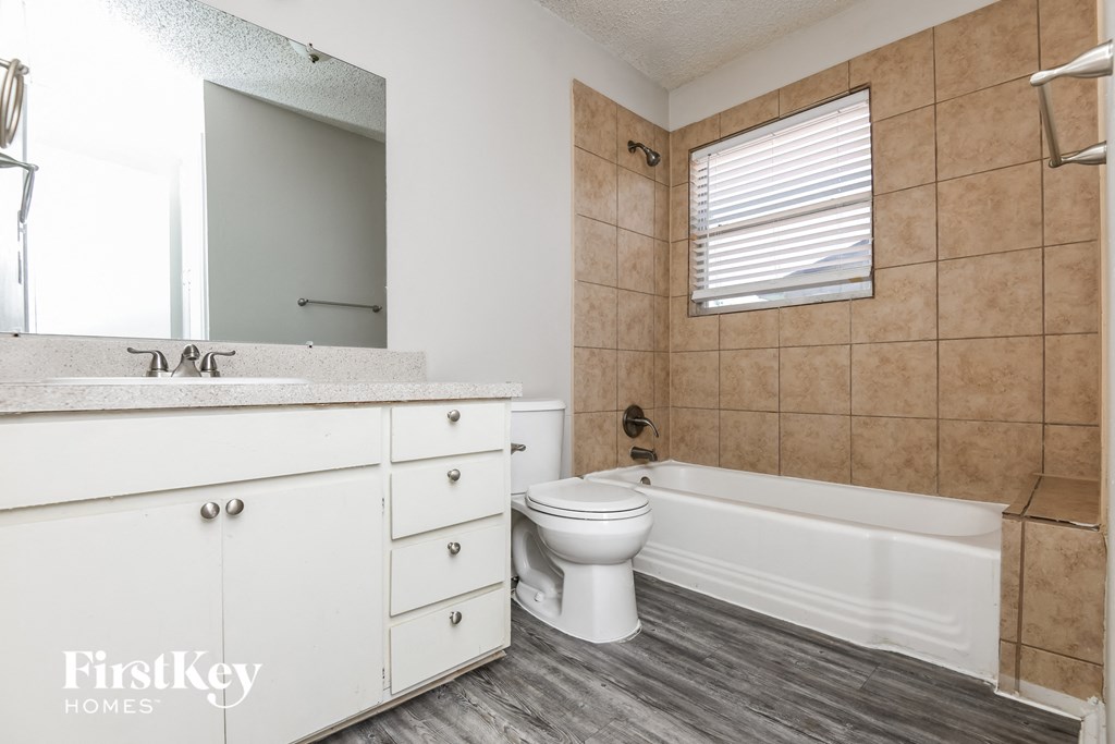 a bathroom with a toilet and a tub and a sink