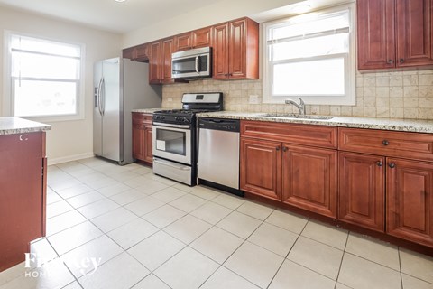 A kitchen with brown cabinets and white appliances.