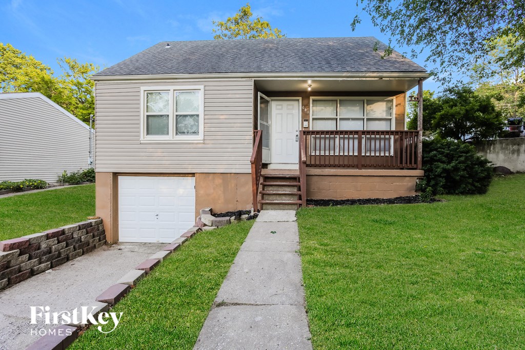 a small gray house with a sidewalk in front of it