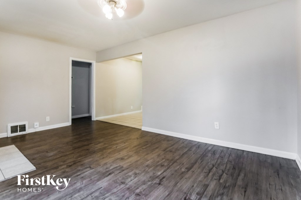 an empty living room with white walls and wood flooring