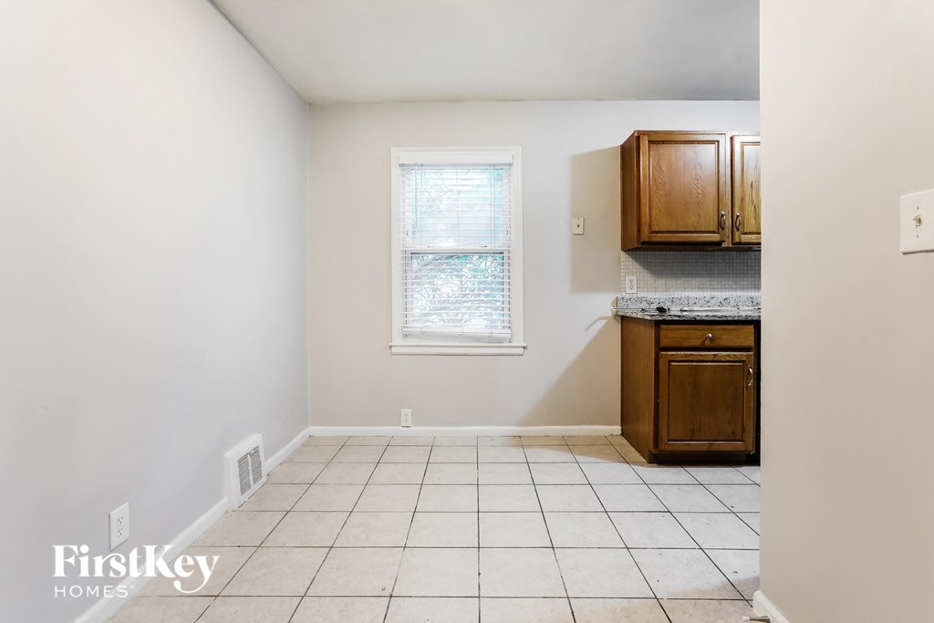 a kitchen with a tiled floor and a window