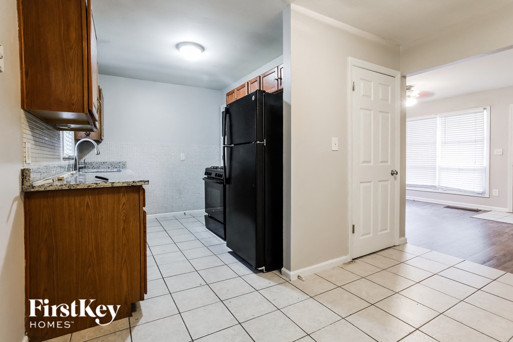 a kitchen with a black refrigerator and a sink