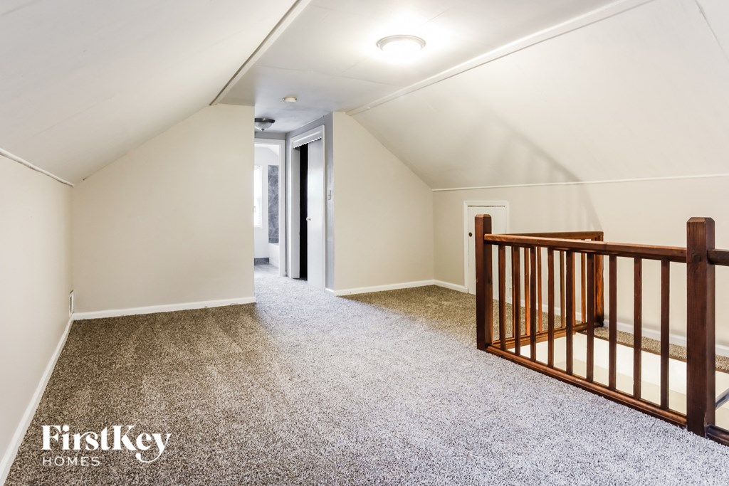 a nursery with a crib in a white room with a carpet floor and a hallway