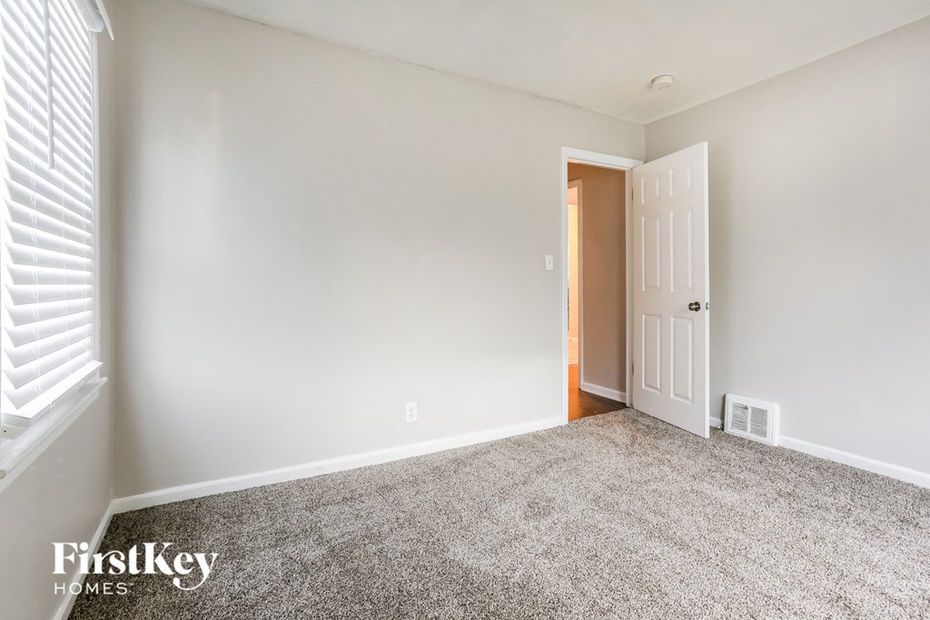a bedroom with a carpeted floor and a door to a closet