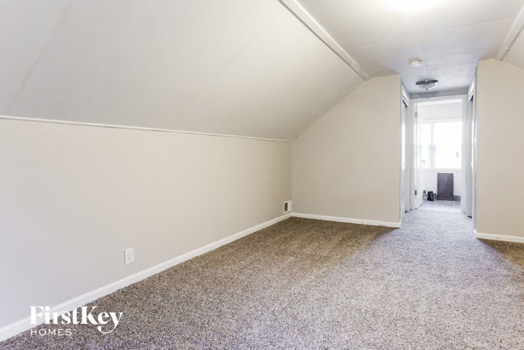 a empty room with a carpeted floor and a white wall