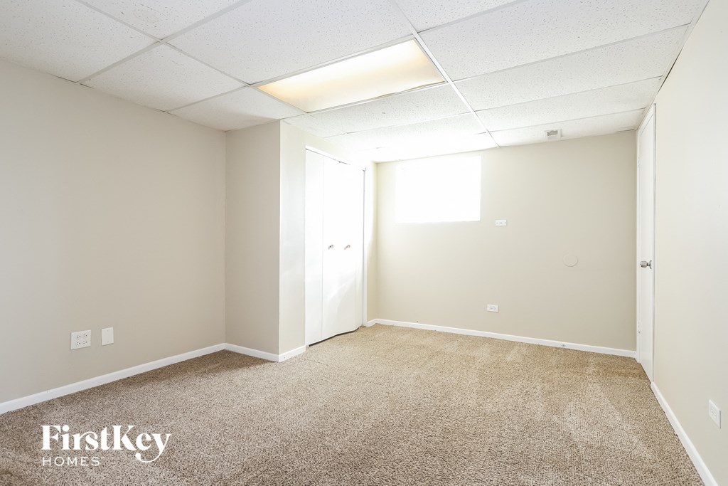 A room with a carpeted floor and a door on the right side.