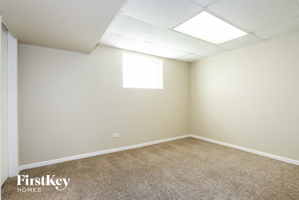 A room with a carpeted floor and a window letting in natural light.