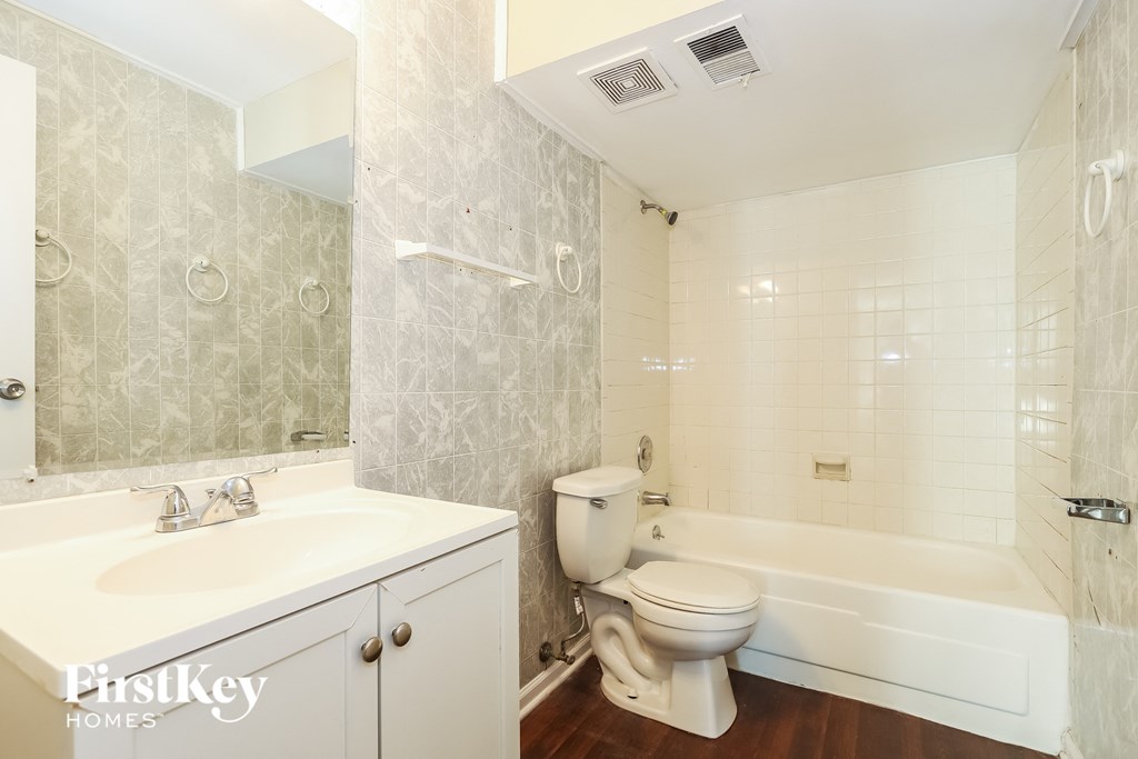 A white bathroom with a toilet, sink, and bathtub.