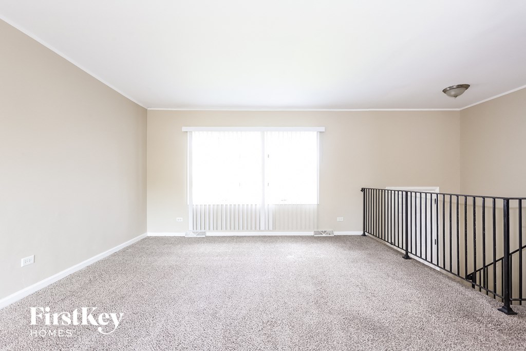 A sparsely furnished room with a window and radiator.