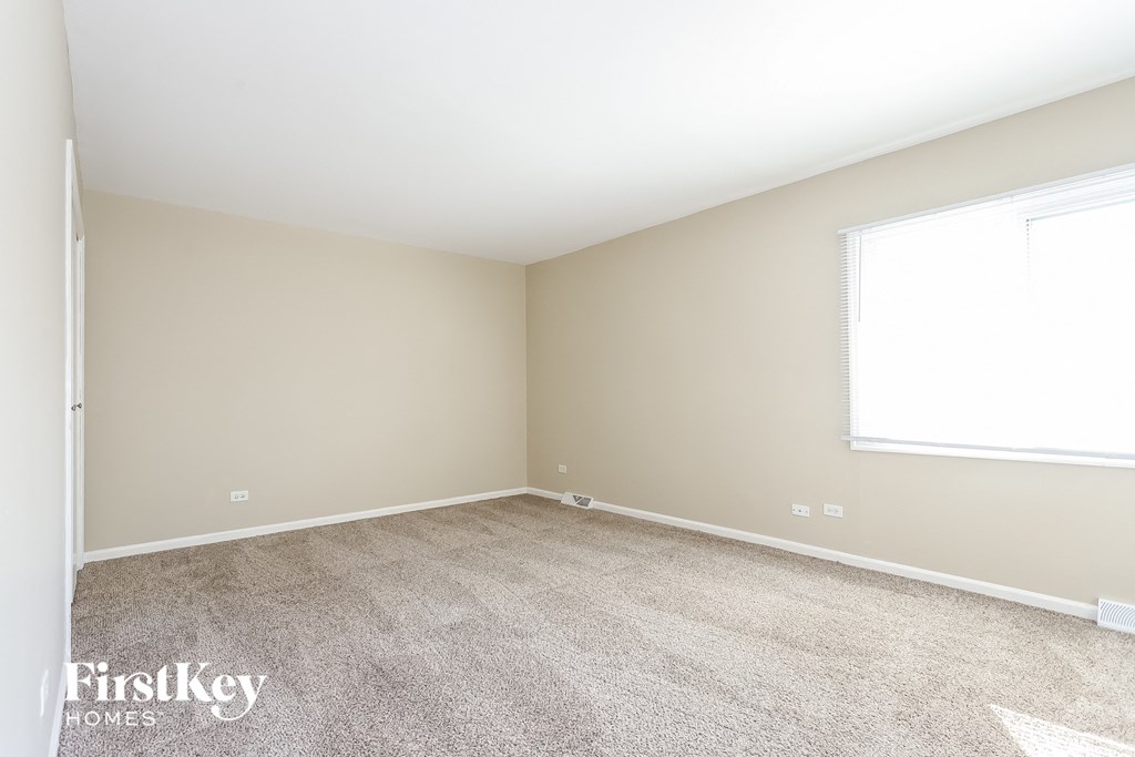 A room with a carpeted floor and a window.