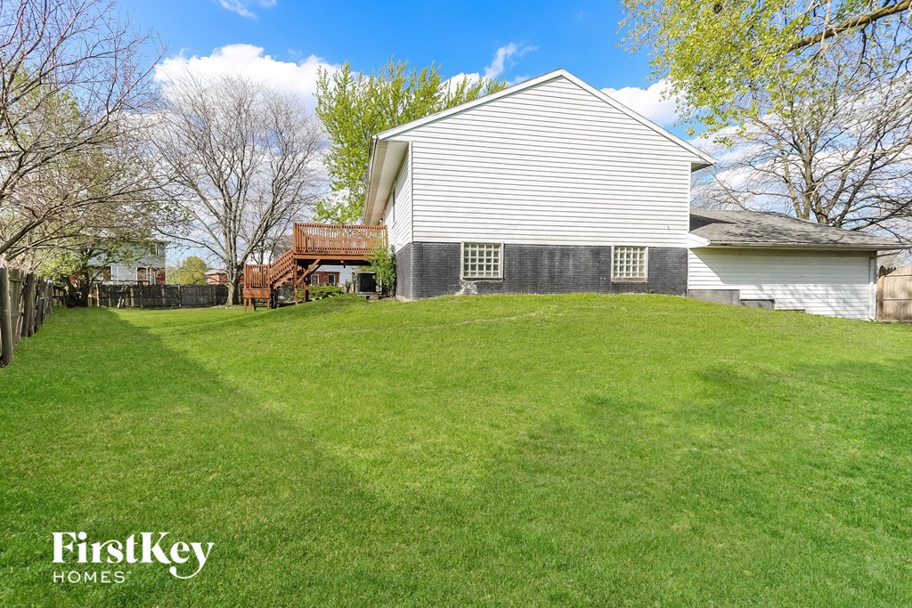 A white house with a green lawn in front of it.