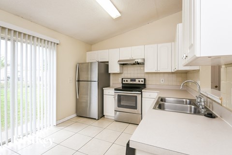 a kitchen with white cabinets and stainless steel appliances