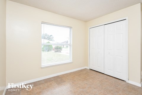 a bedroom with a large window and a door to the backyard