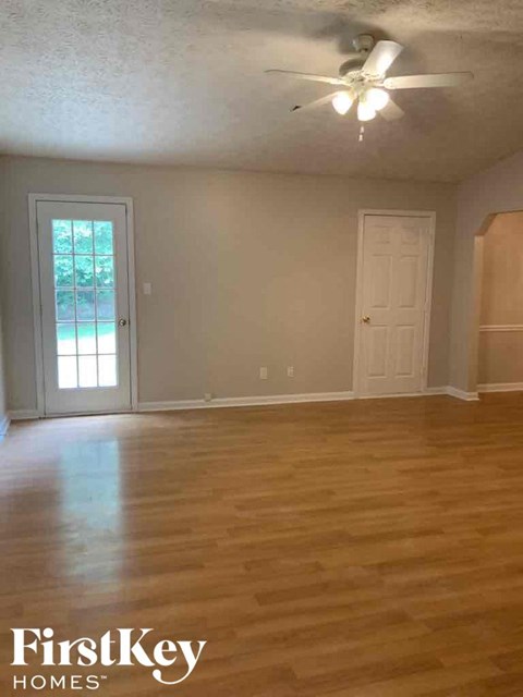A room with wooden floors and a ceiling fan.