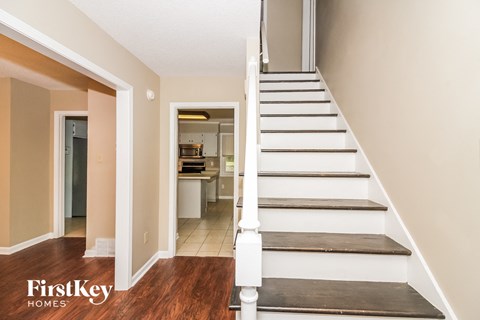 a staircase leading up to a kitchen in a home with white stairs