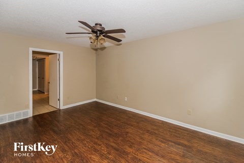 a living room with wood floors and a ceiling fan