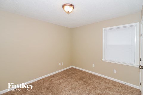 a bedroom with a carpeted floor and a window