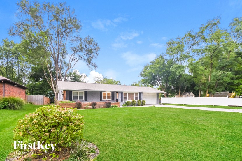 A house with a lawn and trees in the background.