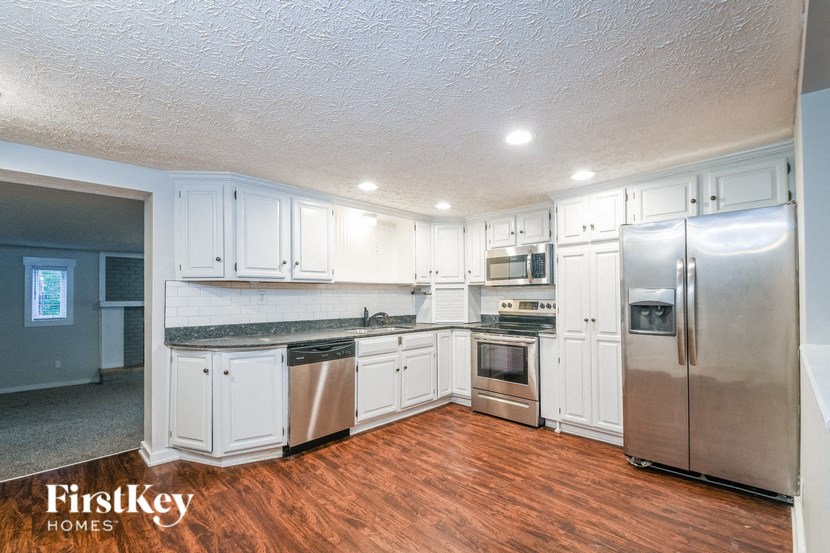 A kitchen with white cabinets and stainless steel appliances.