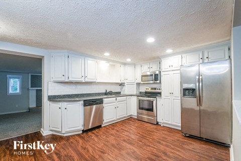 A kitchen with white cabinets and stainless steel appliances.