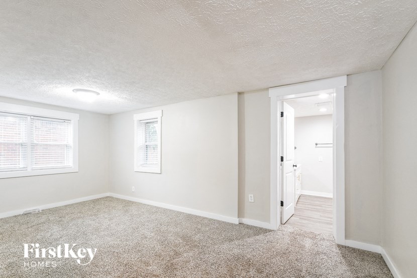 A room with a carpeted floor and a doorway leading to another room.