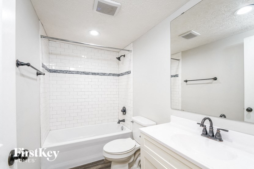A white bathroom with a toilet, sink, and bathtub.