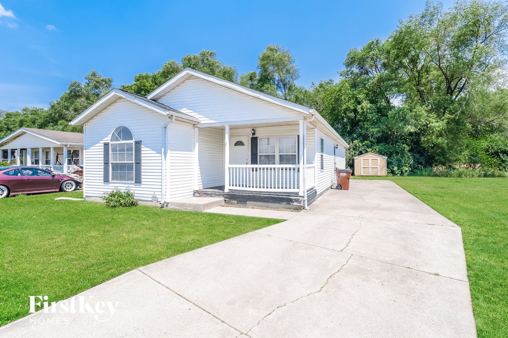 a small white house with a sidewalk in front of it