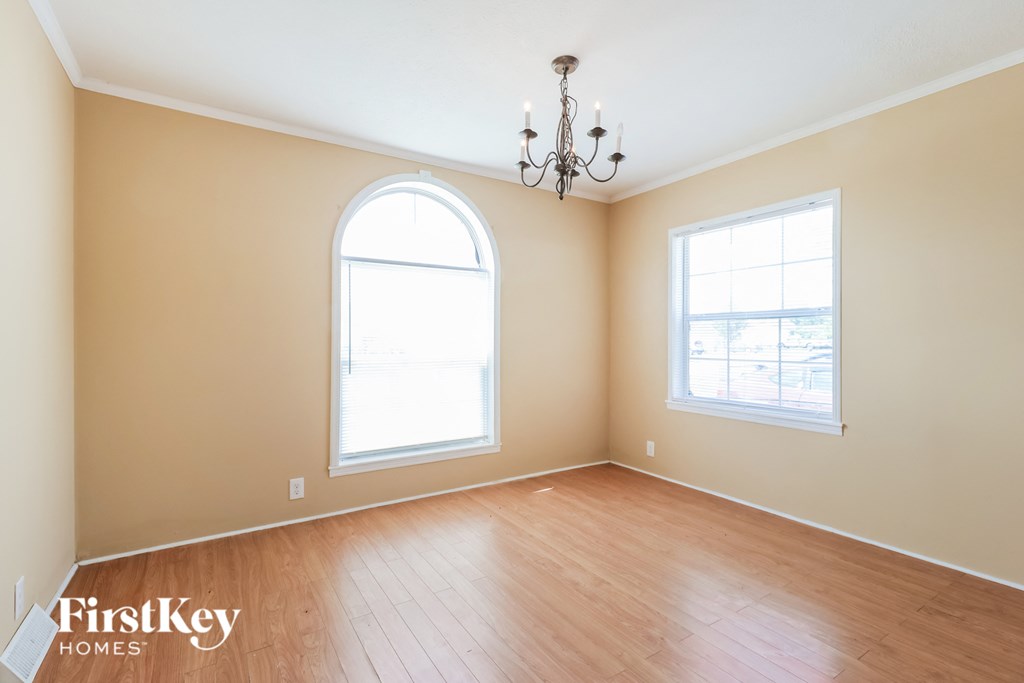 the living room with wood floors and an arched window