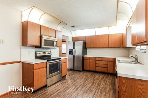 a kitchen with wooden cabinets and stainless steel appliances