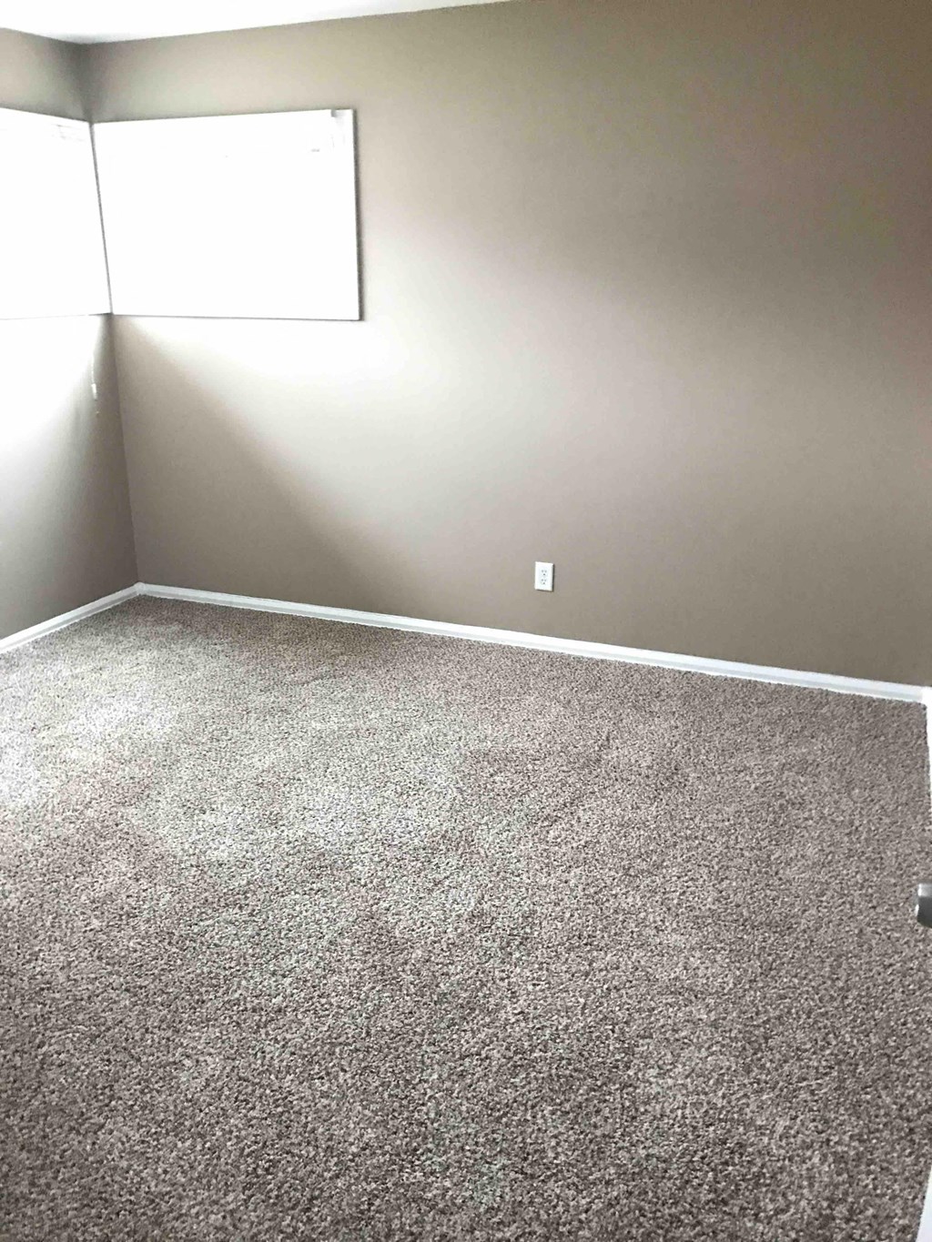 a room with a carpeted floor and a window