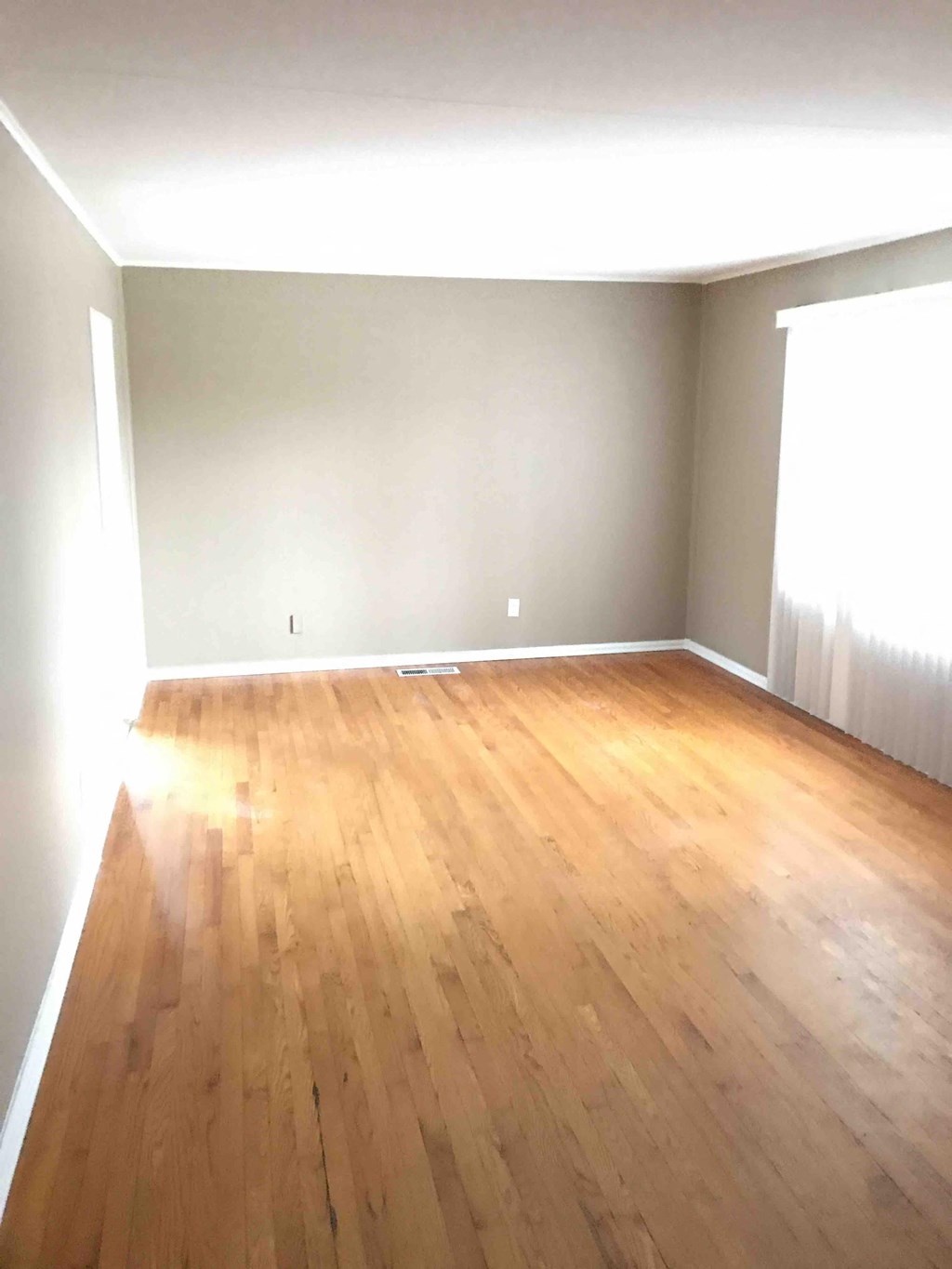 an empty living room with wooden floors