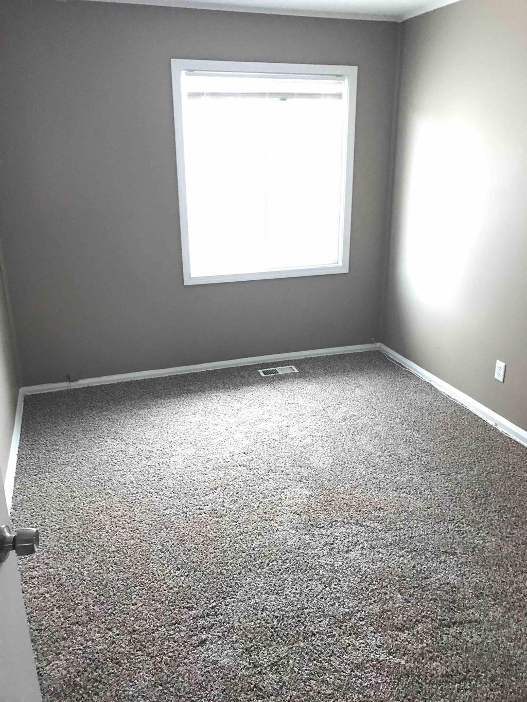a room with a carpeted floor and a window