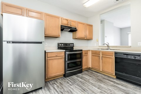 A kitchen with wooden cabinets and a stainless steel refrigerator.