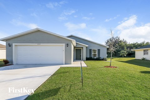 a white house with a lawn and a white garage door