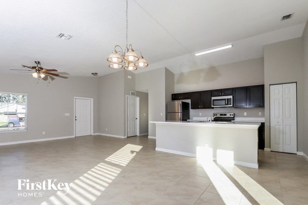 a kitchen and living room with an island and a ceiling fan