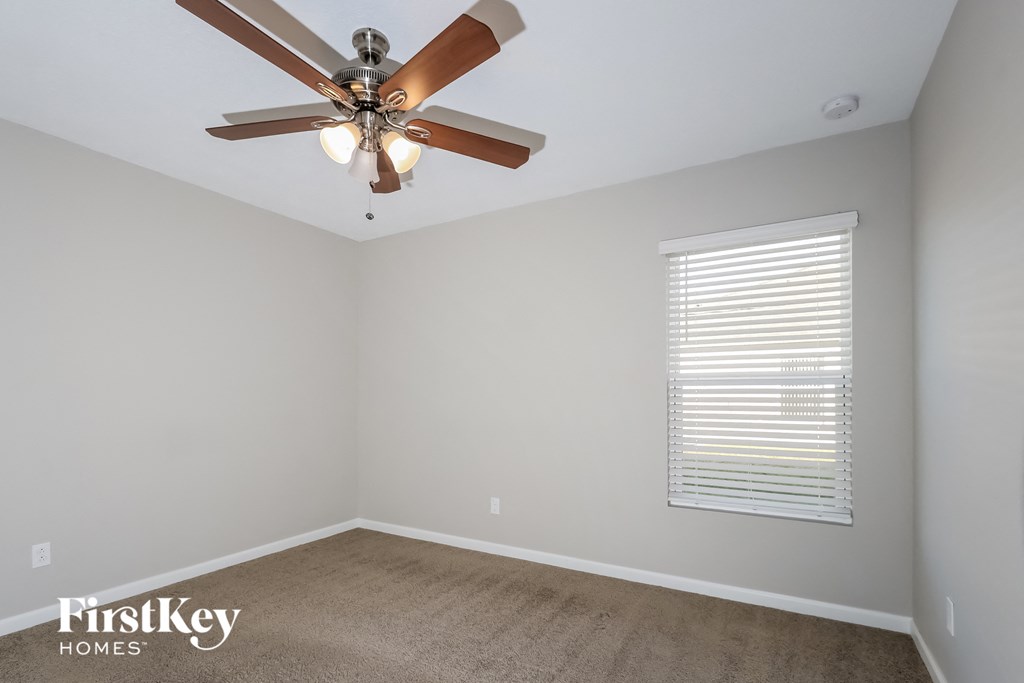 a bedroom with a ceiling fan and a window