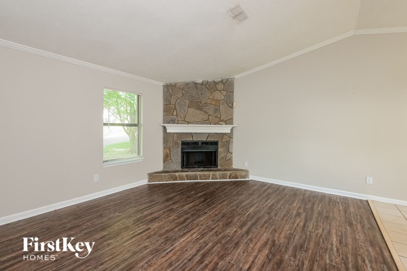 a living room with a fireplace and wooden floors