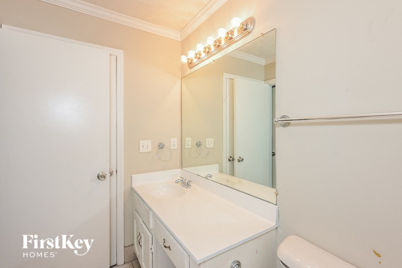 a white bathroom with a sink and a mirror