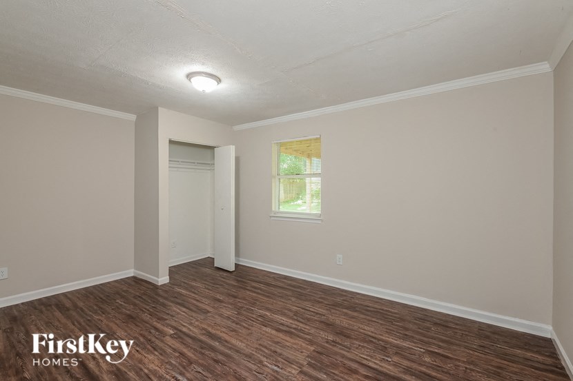the living room of a home with a wood floor and white walls
